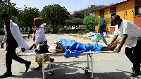 Paramedics carry an unidentified man injured in the explosion in Afgoye in Somalia