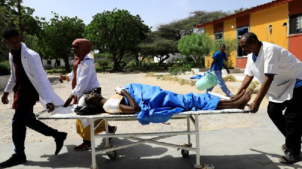 Paramedics carry an unidentified man injured in the explosion in Afgoye in Somalia