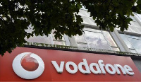 Vodafone branding is seen outside a retail store in London on November 12, 2013